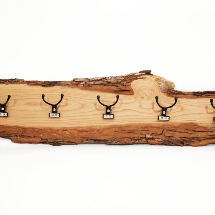 A 5 Hook Elm Wood coat peg hanging on a log.