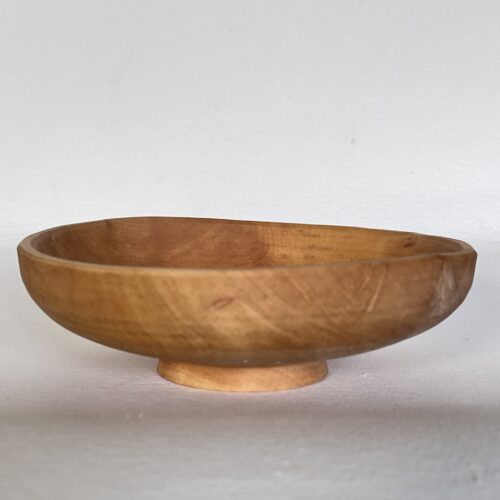 A wooden bowl sitting on a white surface.