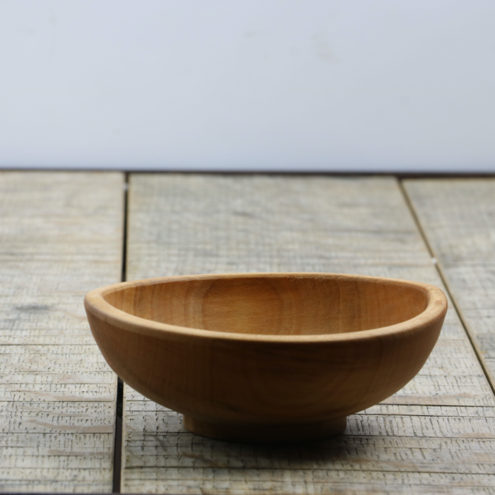 A hand carved spalted sycamore bowl sitting on top of a wooden table.