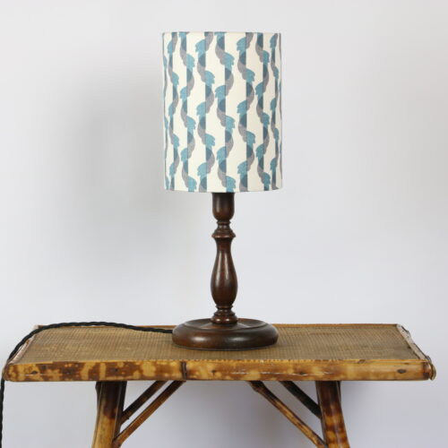 A lamp on a wooden table with a blue and white pattern.