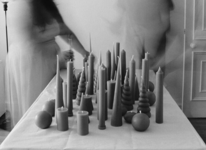 A black and white photo of candles on a table.