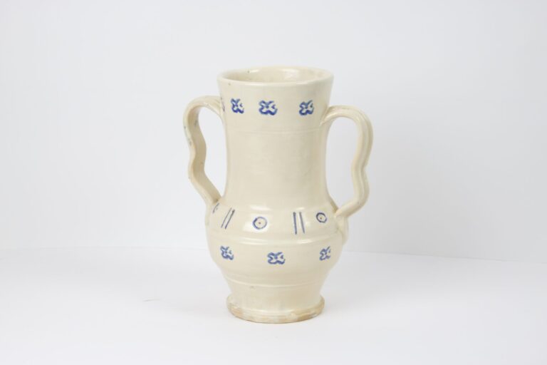 A white vase with blue designs on it.