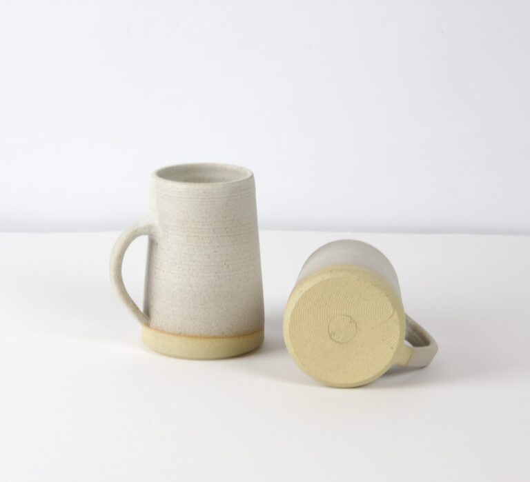 An image of two mugs on the white surface.