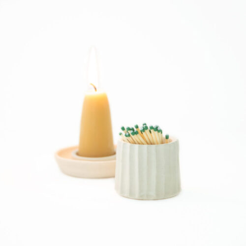 A candle and matches in a holder.